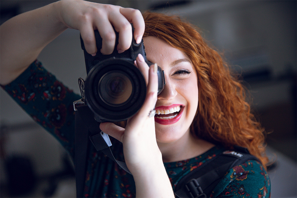 Close up of female student using profesional camera.